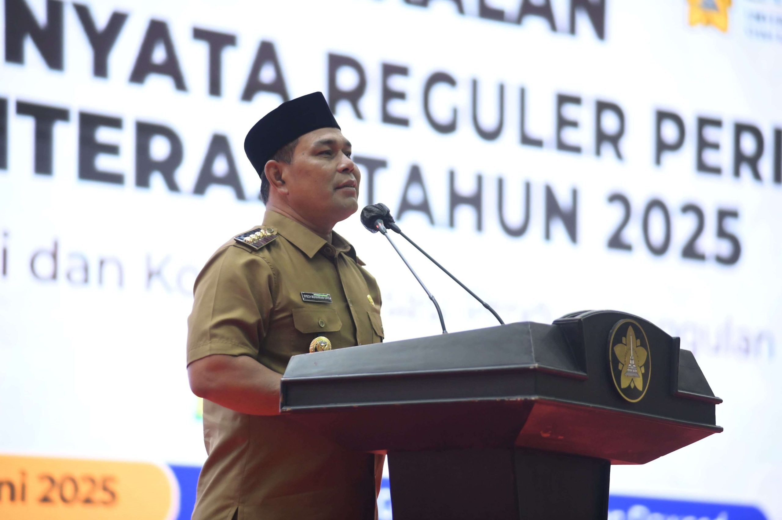 Bupati Aceh Besar Muharram Idris memberi sambutan pada pembekalan KKN Mahasiswa USK periode XXVI di Hall Gedung AAC Prof. Dayan Dawood, Banda Aceh, Senin (16/6/2025) (FOTO: MC ACEH BESAR)