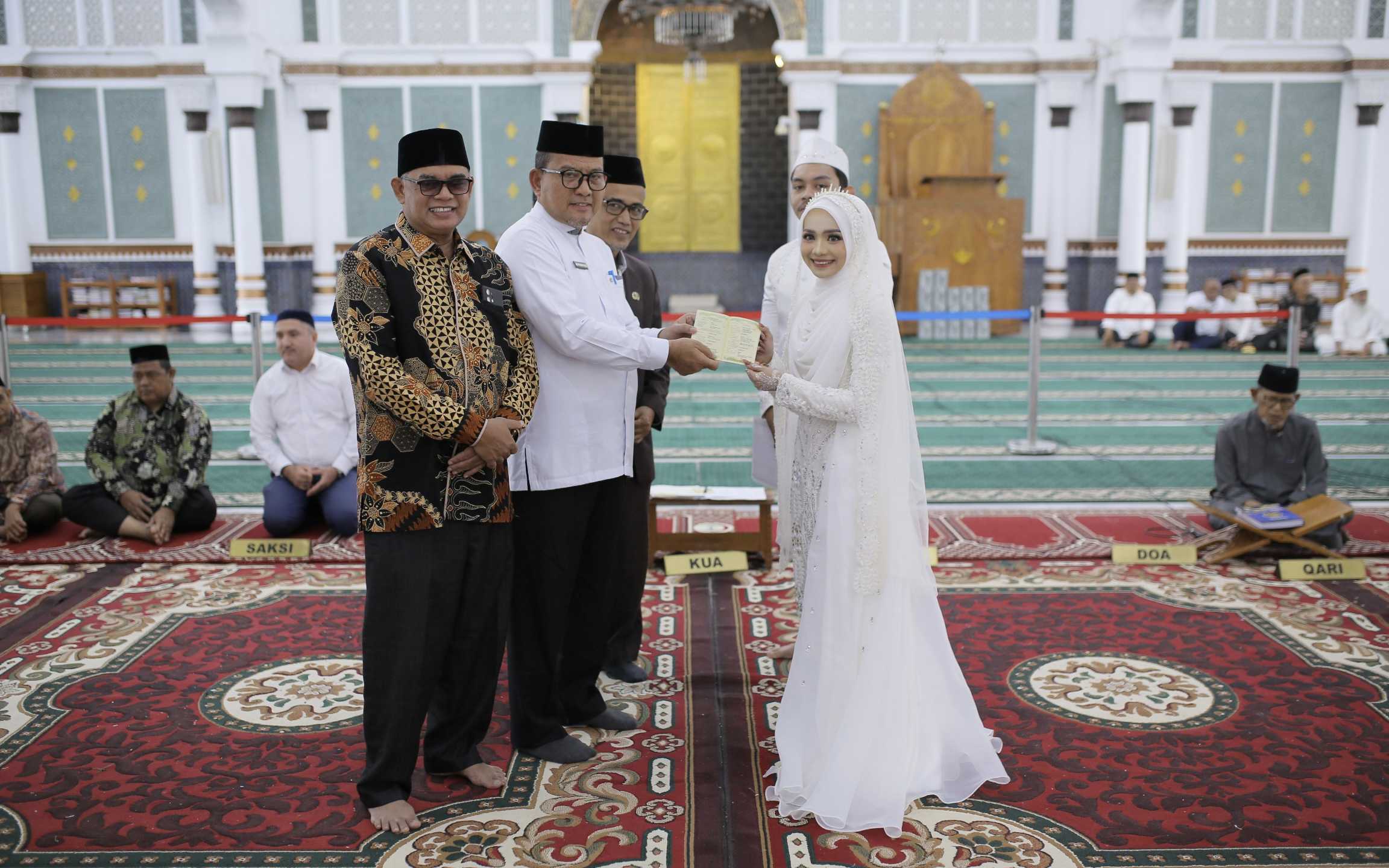 Kakanwil Kemenag Aceh Serahkan Buku Nikah dan Sertifikat Wakaf Tunai Catin. (Foto: Kemenag Aceh)