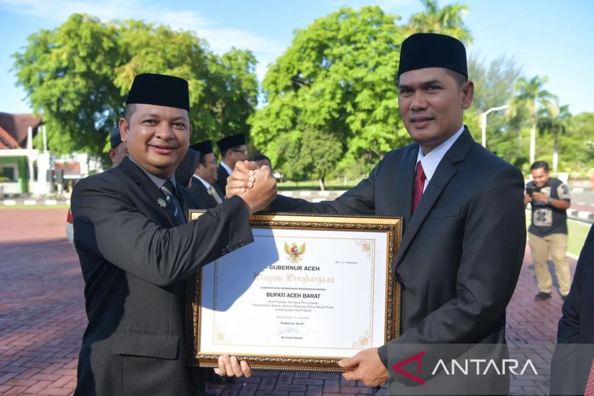 Plt Sekda Aceh, M Nasir Samaun menyerahkan piagam penghargaan kepada Pemkab Aceh Barat diterima Asisten Pemerintahan Aceh Barat Ifan Murdani (kiri), pada peringatan Hari Koperasi ke-78 tingkat Provinsi Aceh yang digelar di halaman Kantor Gubernur Aceh di Banda Aceh, Kamis (17/7/2025). (Foto: ANTARA)