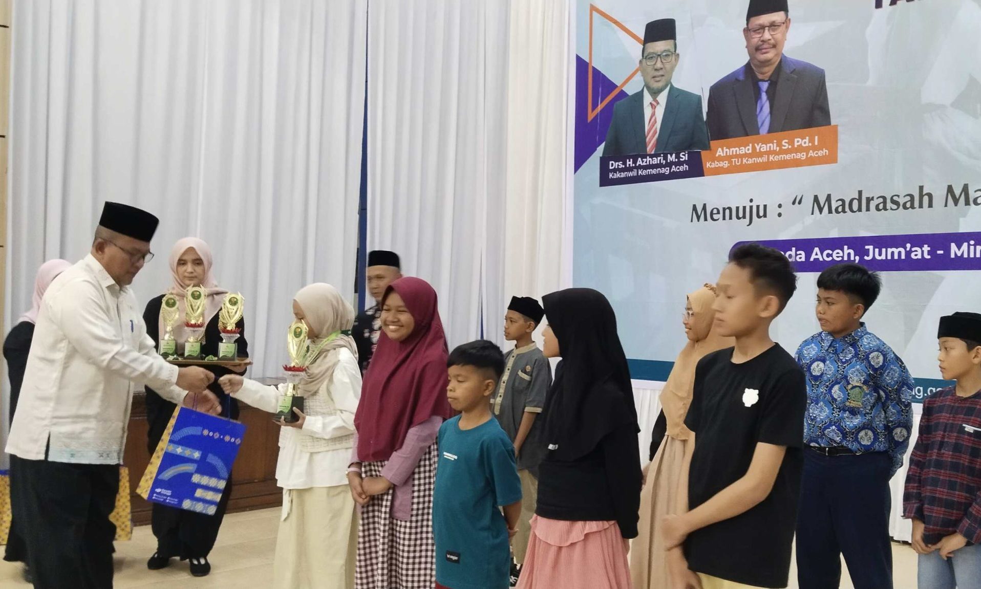 Kepala Kantor Wilayah Kementerian Agama Provinsi Aceh, Drs. H. Azhari, M.Si, menyerahkan penghargaan kepada Juara Olimpiade Sains Madrasah Aceh (OSMA) 2025. (Foto: For Nukilan)