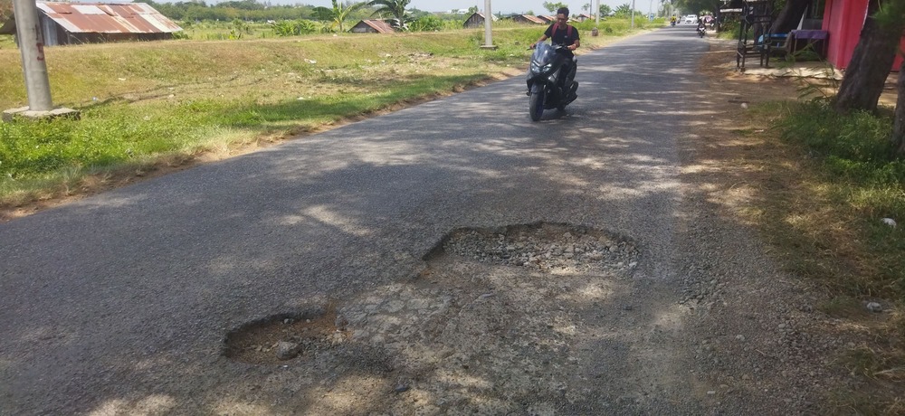 Jalan rusak dan berlubang di Desa Lamreung, Kamis (21/8/2025). (Foto: Nukilan/Sammy)