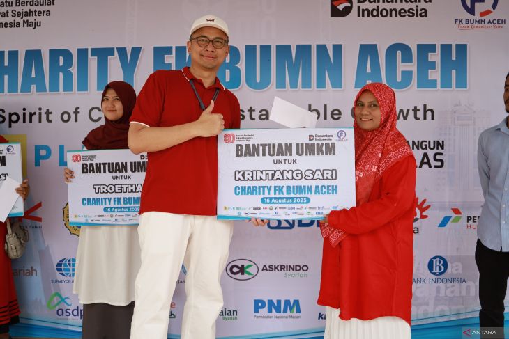 Ketua FK BUMN, Imsak Ramadhan, menyerahkan bantuan kepada UMKM Krintang Sari dalam kegiatan Charity FK BUMN Aceh, di Aceh Besar, Aceh, Sabtu (16/8/2025). (Foto: ANTARA/Nurul Hasanah)