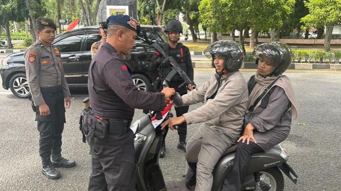 Tim patroli KRYD Polda Aceh memasang bendera merah putih pada kendaraan yang melintas di kawasan Simpang Lamteumen, Kota Banda Aceh, Minggu (10/8/2025). Pemasangan bendera dilakukan dalam rangka menyemarakkan HUT ke-80 RI. (Foto: HUMAS POLDA ACEH)