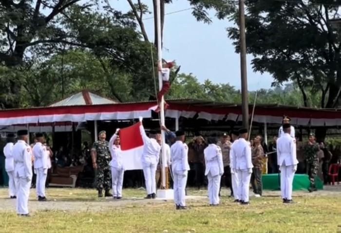 Julian Saputra, murid kelas VI SD Keude Seumot, spontan memanjat tiang bendera setelah melihat tali pengikat terlepas. (Foto: Detik)