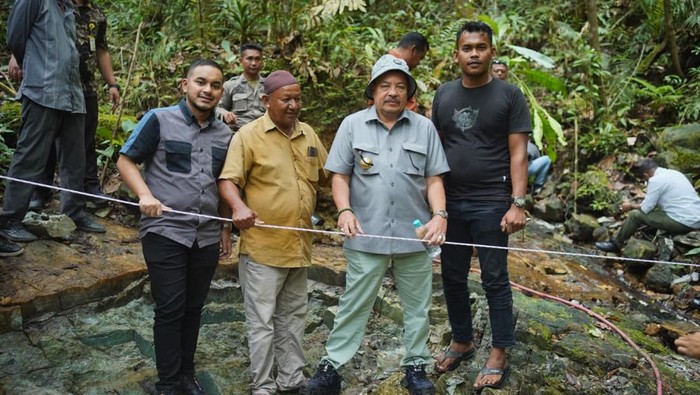 Rombongan Bupati Nagan Raya Teuku Raja Keumangan berdiri di atas batu giok raksasa yang baru ditemukan. (Foto: Diskominfo Nagan Raya)