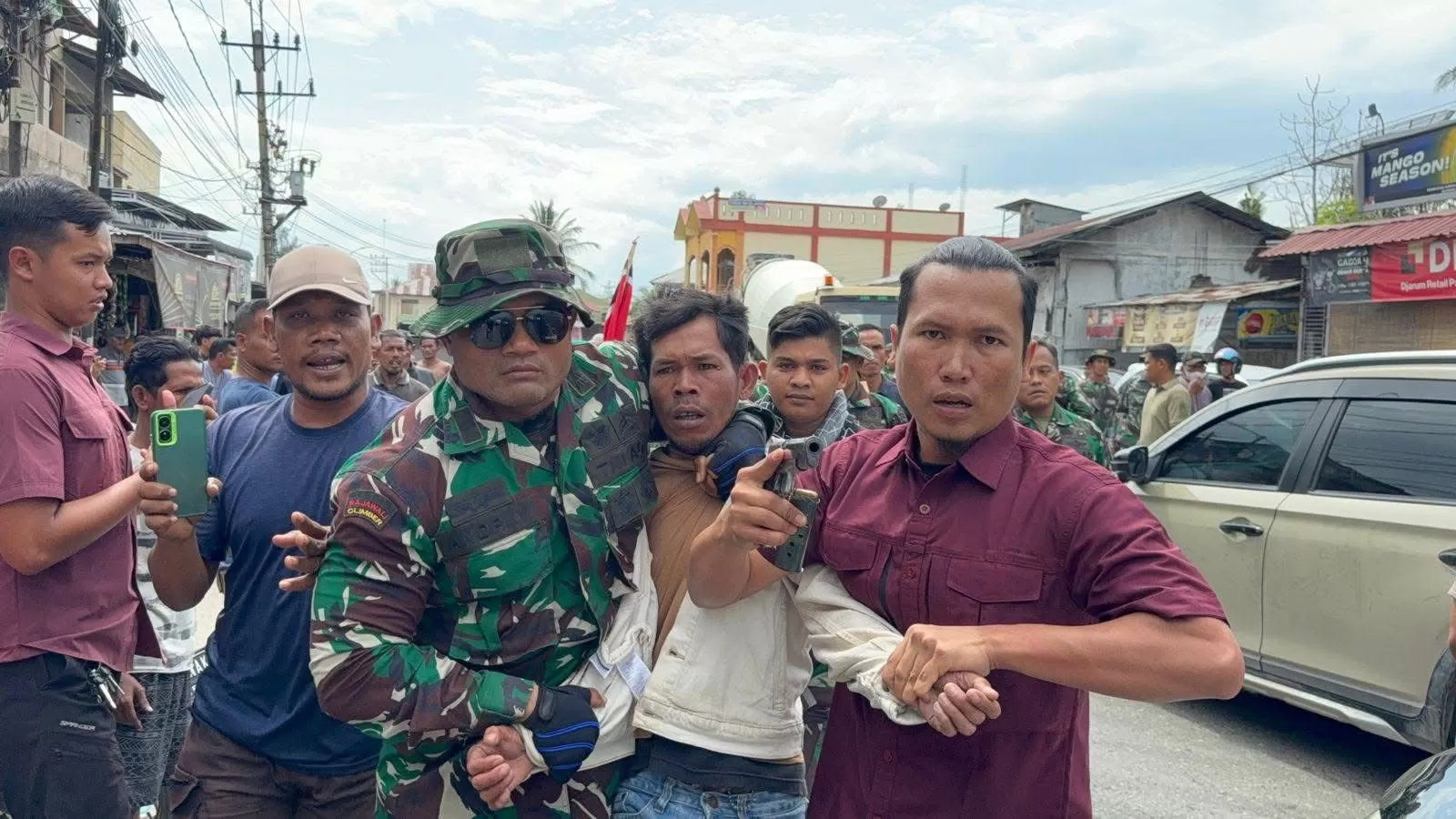 Para prajurit TNI dari Kodam Iskandar Muda mengamankan salah seorang massa aksi pengibaran bendera GAM pada Kamis (25/12). (FOTO: Rakyat Aceh)