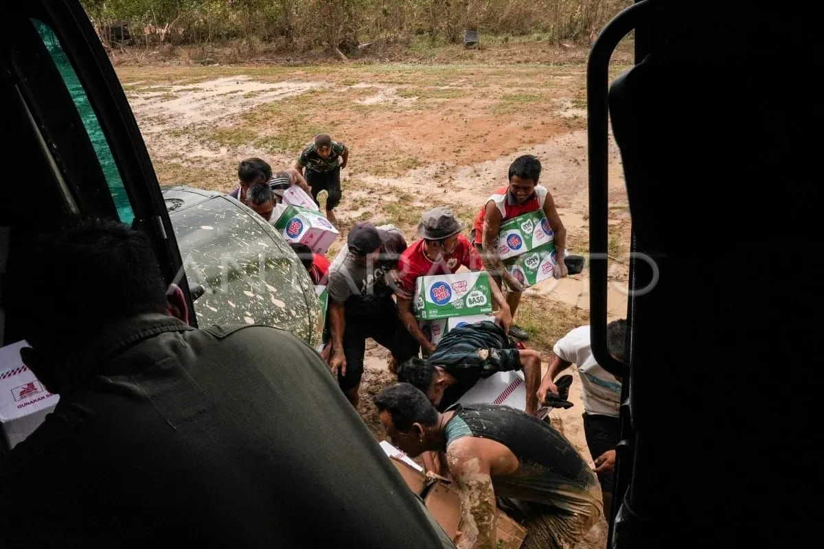 Sejumlah warga mengambil bantuan logistik makanan yang didistribusikan dari Helikopter Caracal Skadron Udara 8 Lanud Atang Sendjaja di Aceh Tamiang, Aceh, Rabu (3/12/2025). (ANTARA FOTO)