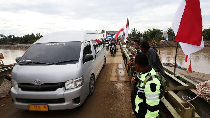 Warga dan kendaraan melewati jembatan darurat bailey Krueng Tingkeum yang baru selesai dibangun di Kuta Blang, Bireuen, Aceh, 27 Desember 2025. (Foto: Antara/Irwansyah Putra)