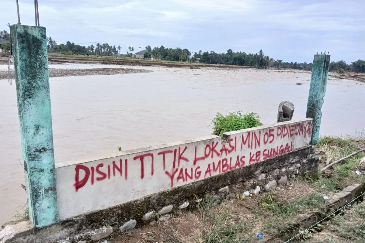 Satu-satunya fondasi tersisa dari MIN 05 Pidie Jaya, Aceh yang hilang diterjang banjir bandang, dan telah ditandai dengan tulisan oleh warga setempat, di Kabupaten Pidie Jaya, Aceh, Minggu (14/12/2025). (Foto: ANTARA/Rahmat Fajri)