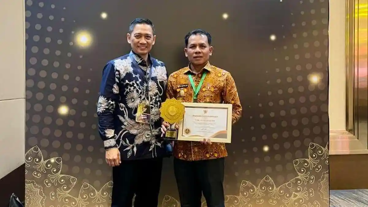 Plt Bupati Aceh Selatan, Baital Mukadis didampingi Kepala BPJS Kesehatan Cabang Tapaktuan, Mahmul Ahyar menerima penghargaan UHC Award 2026. (Foto: Humas Pemkab Asel)