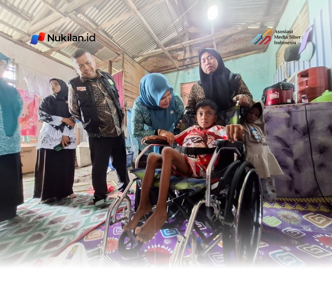 Ketua Staf Ahli TP PKK Aceh, Mukarramah Fadhlullah, menyerahkan bantuan kursi roda serta perlengkapan sekolah kepada Sultan Al Vayar, anak yang terdampak polio, di Kembang Tanjong, Kabupaten Pidie, Kamis (20/8/2026). (FOTO: FOR NUKILAN)