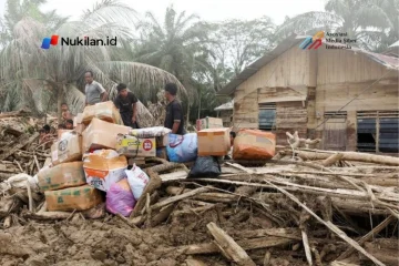 Para penyintas berdiri di dekat pasokan bantuan di daerah yang terdampak banjir bandang mematikan menyusul hujan lebat di Karang Baru, Kabupaten Aceh Tamiang, Provinsi Aceh, Indonesia, 6 Desember 2025. (FOTO: REUTERS/Ajeng Dinar Ulfiana)