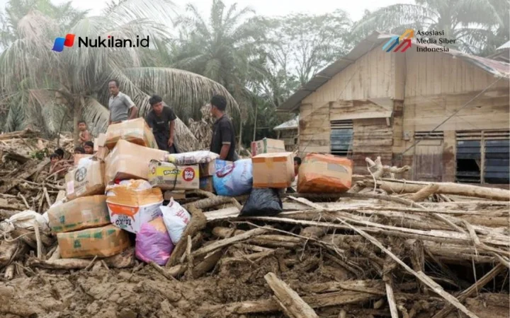 Para penyintas berdiri di dekat pasokan bantuan di daerah yang terdampak banjir bandang mematikan menyusul hujan lebat di Karang Baru, Kabupaten Aceh Tamiang, Provinsi Aceh, Indonesia, 6 Desember 2025. (FOTO: REUTERS/Ajeng Dinar Ulfiana)