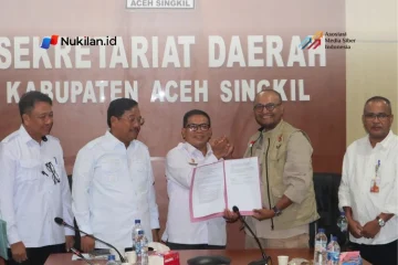 Sekretaris Daerah Aceh Singkil, Edy Widodo dan Ketua Tim Satuan Tugas Percepatan Rehabilitasi dan Rekonstruksi Pusat Kementerian Dalam Negeri, Imran, bersama Bupati Safriadi Oyon (ketiga dari kiri) memperlihatkan naskah penandatanganan berita acara di Kantor Sekretariat Daerah Kabupaten Aceh Singkil, pada Rabu, 7 Oktober 2026. (Foto: For Nukilan)