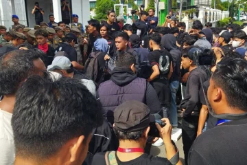 Massa aksi dihadang barikade polisi dan personel Satpol PP-WH di pintu masuk Kantor Gubernur Aceh, Selasa (20/10/2026). (Foto: Nukilan/Sammy)
