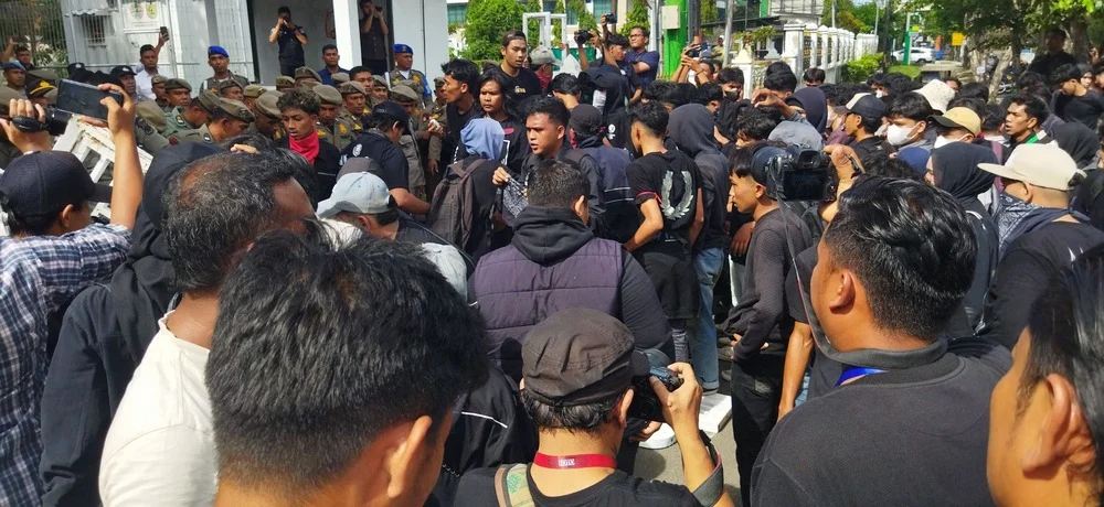 Massa aksi dihadang barikade polisi dan personel Satpol PP-WH di pintu masuk Kantor Gubernur Aceh, Selasa (20/10/2026). (Foto: Nukilan/Sammy)